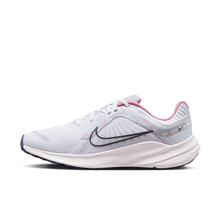 The image shows a pair of Women’s Nike running shoes, emphasizing their sleek, lightweight design and supportive sole.